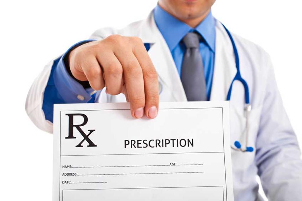 Image of male doctor holding a prescription pad for medication