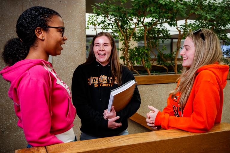 Students standing and talking by staircase
