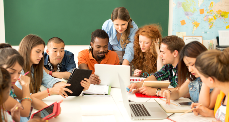 Several people gathered around table collaborating