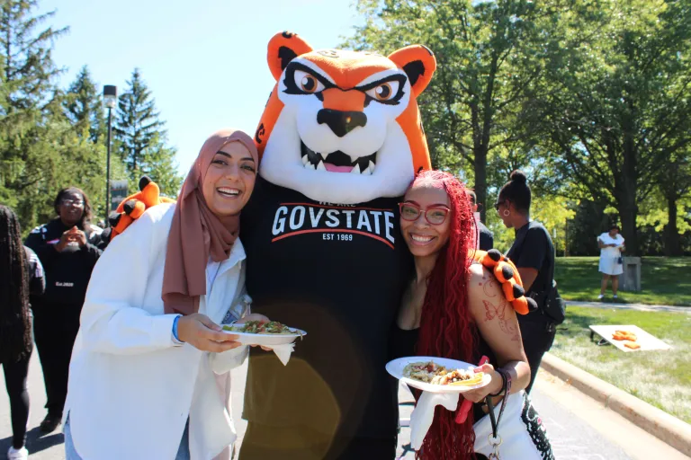 Jax the mascot and two students enjoying an outdoor event