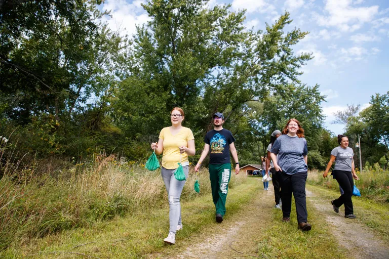 A group of people walking down a nature trail