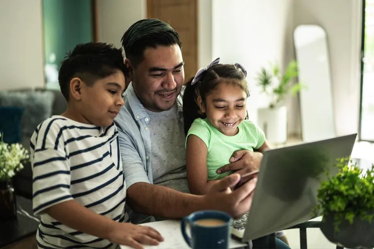 Latinx family in front of a laptop