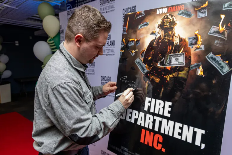 Man signing poster