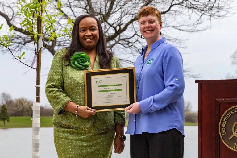 Dr. Cheryl Green and Jamie Viebach holding a certificate for the GovState Arboretum