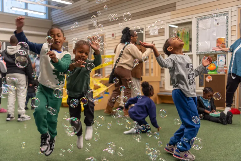 Children at the Family Development Center playing with bubbles
