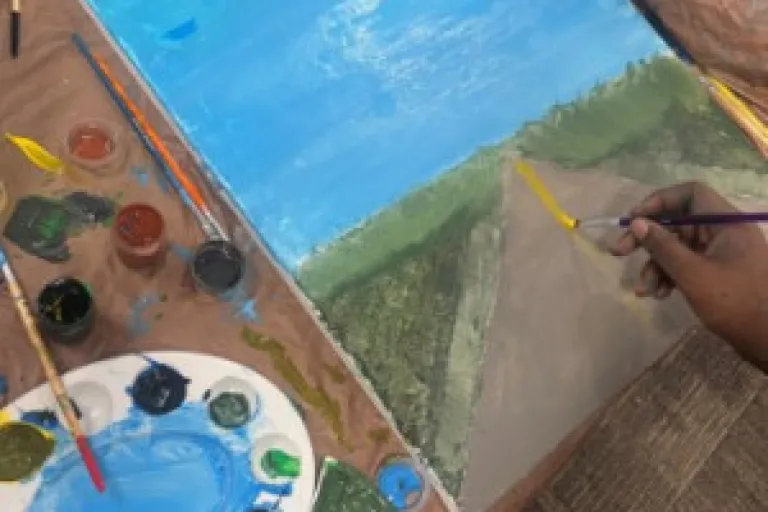 An abstract painting with visible, expressive brushstrokes in a vibrant palette of blues, yellows, reds, and black, suggesting a dynamic landscape or scene.