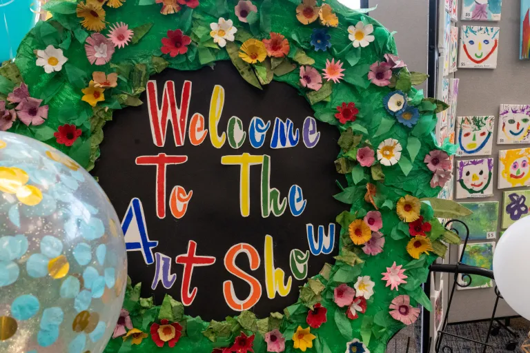 Handmade flower wreath with sign saying Welcome to the Art Show