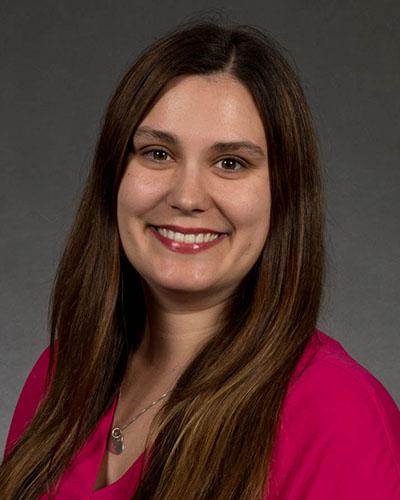 Woman with long brown hair, in red shirt