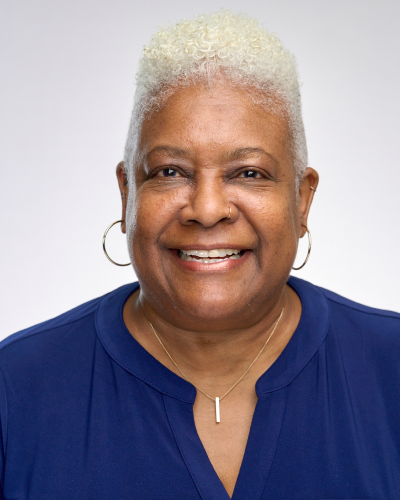 Woman with short white hair, in blue top