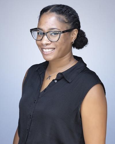 Woman with black hair, in glasses and blue shirt