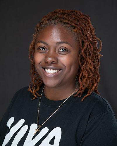 Woman with brown hair in black and white t-shirt