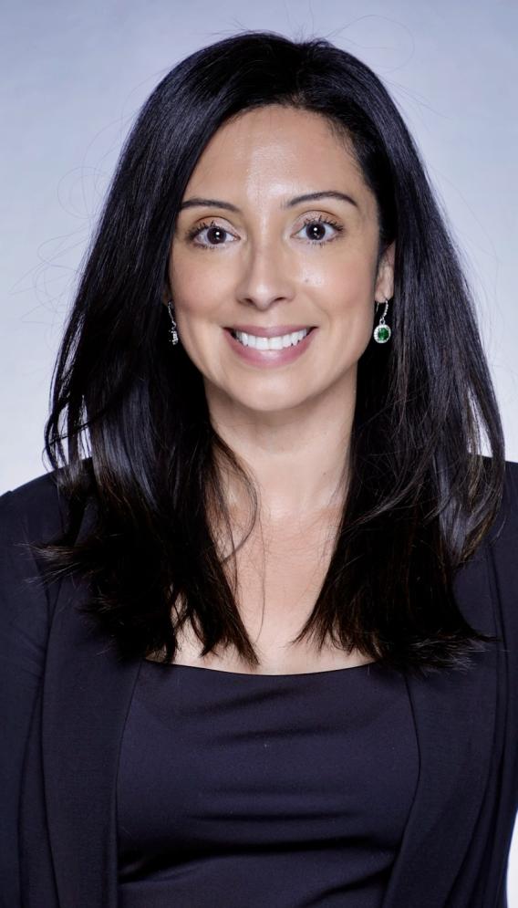 Professional headshot, woman with long black hair, in a dark blue top and sweater