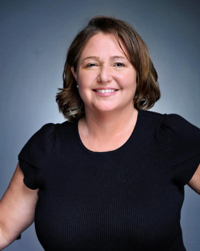 Professional headshot of woman with brown hair, in a black shirt