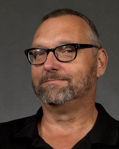 Professional headshot of man in glasses and beard