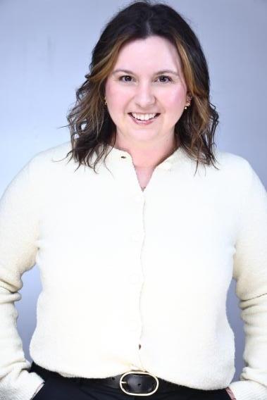 Professional headshot, woman with shoulder-length brown hair, wearing a white blouse. 