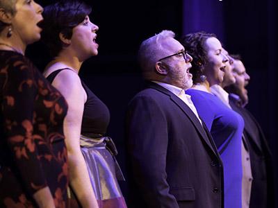 A group of singers singing on a stage