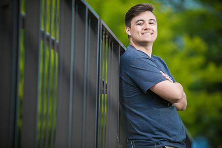 Logan Krska leaning on a black fence