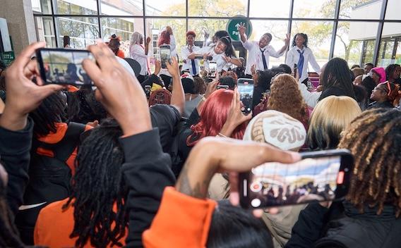 Crowd holding up phones to film musical performers on a stage at GovState Homecoming Pep Rally