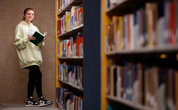 Caucasian female freshman student in the library