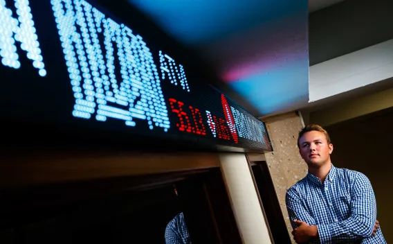 Person standing next to a stock ticker