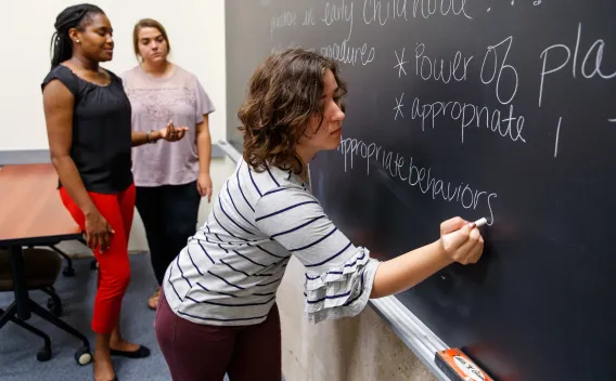Person writing on chalkboard