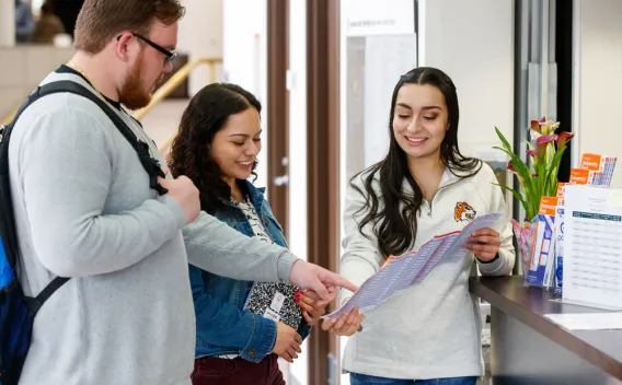 LatinX staff member talking to students