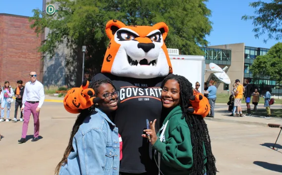Jax the mascot and two students enjoying an outdoor event