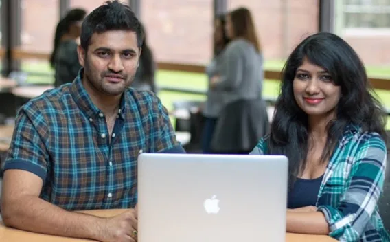 Two students in front of a computer