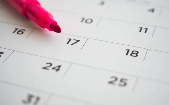 Image of a partial calendar and a pink marker