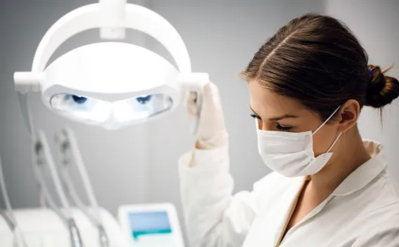 Image of woman with medical mask on and dental equipment