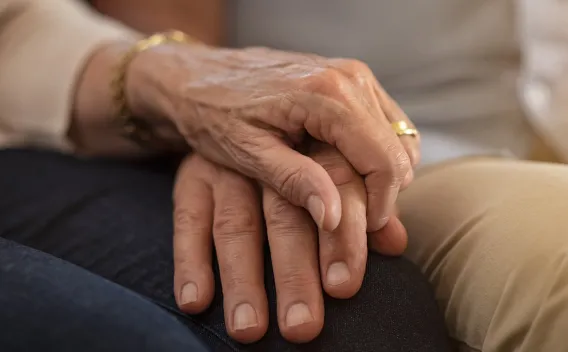 Image of two sets of legs with two hands on top of one another