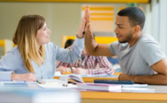 Two students giving High Five to each other