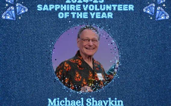 Graphic announcing the 2024–25 Sapphire Volunteer of the Year, featuring a circular portrait of Michael Shaykin on a denim‑style background with sapphire illustrations
