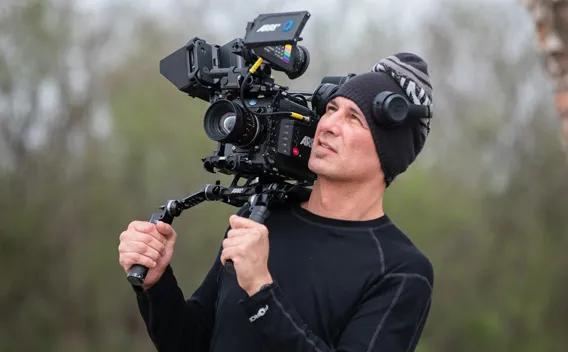 Man operating a professional video camera on his shoulder.
