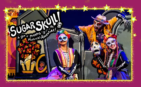 Graphic: Three performers in vibrant Día de los Muertos costumes and sugar skull makeup.