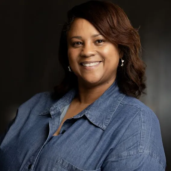 Woman with medium-length hair, wearing denim, button-down shirt