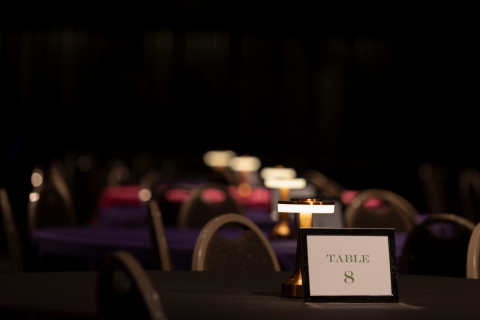 able with a “Table 8” sign in a dimly lit event space.